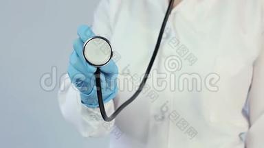 医生穿着实验室外套，戴着医用手套，拿着听诊器到照相机，诊所